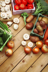 Different vegetables in boxes on wooden background top view