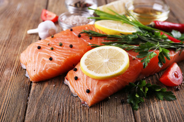 Fresh salmon with spices and lemon on wooden table