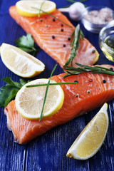 Fresh salmon with spices and lemon on wooden table