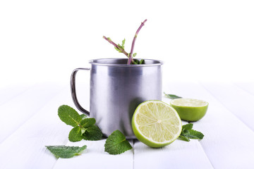 Lemonade in metal cup on wooden background