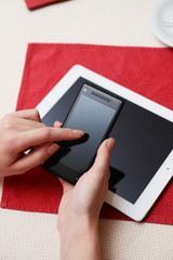 Woman with mobile phone and tablet computer in cafe shop