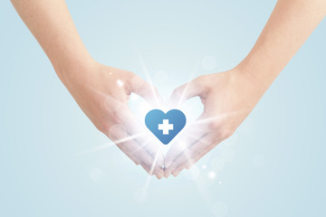 Hands creating a form with heart blue cross