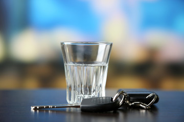 Glass of alcoholic drink and car key,