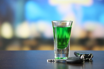 Glass of alcoholic drink and car key,