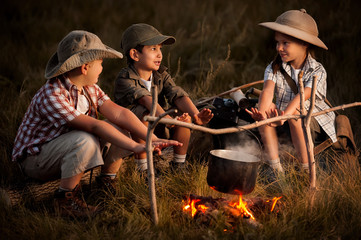 Fototapeta premium Group of children sitting around the campfire travelers