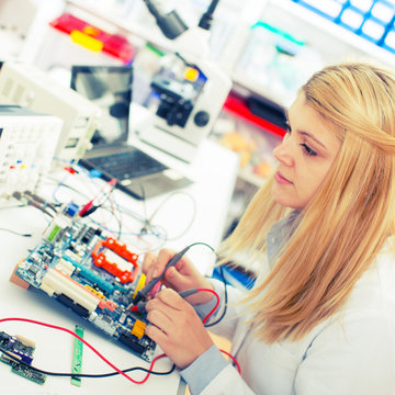girl with a tester and a printed circuit board