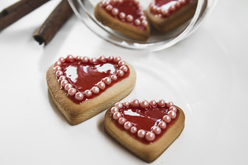 Red hearts cookies on white background and a bowl