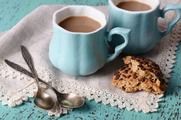 Fototapeta na wymiar Cups of coffee with cookies and napkin on wooden table