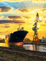 Cargo ship and the port at sunset.