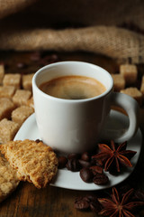 Cup of espresso and tasty cookie on wooden background