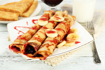 Plate of delicious pancakes with berry jam on wooden background
