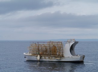 Fototapeta na wymiar Piled fish traps on a small fishing boat in the Adriatic sea