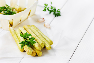 Bread sticks with parsley and garlic on a wooden table