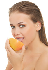 Young nude woman eating grapefruit