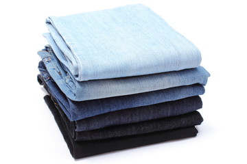 Stack of blue jeans on white background