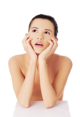 Portrait of pensive nude woman with hands on chin