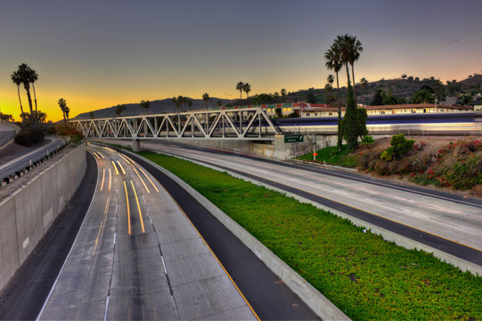 Freeway, trestle, and train all converging on the sunset