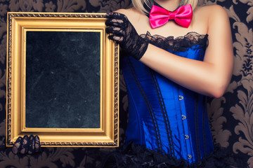 beautiful cabaret woman posing with golden frame against retro w