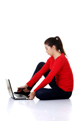 Side view woman sitting cross-legged with laptop