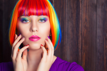 beautiful woman wearing colorful wig and showing colorful nails