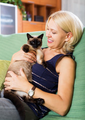 Woman sitting on sofa with her cat