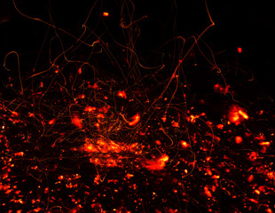 Sparks from the fire on the dark background