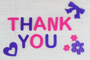 Thank you written with colorful letters on white wood