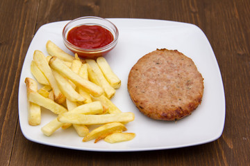 Hamburger with fries and ketchup on wooden table