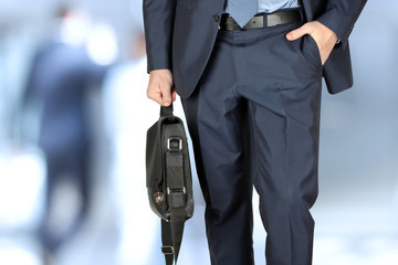 Businessman walking and holding  a  leather briefcase in his han