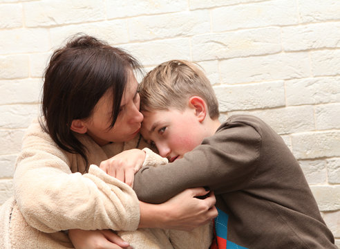 Violence in the family. Mother soothes her son 