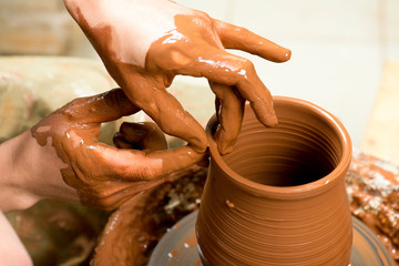 hands of a potter, creating an earthen jar