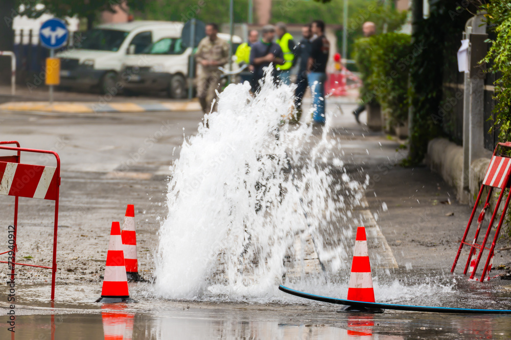 Wall mural road spurt water beside traffic cones