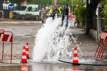Fotobehang road spurt water beside traffic cones © GioRez