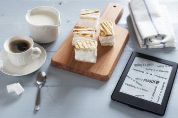 E-book reader on wooden table with text READING IS A PLEASURE