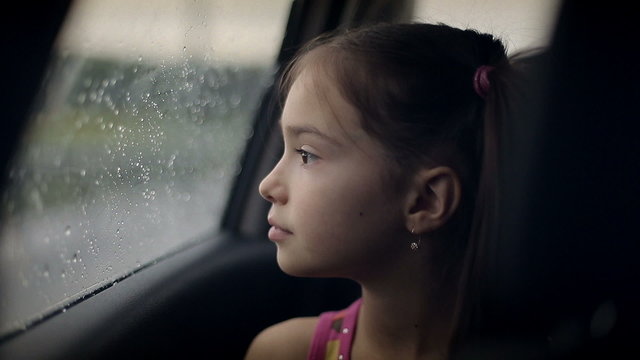 Child female in the car in raining