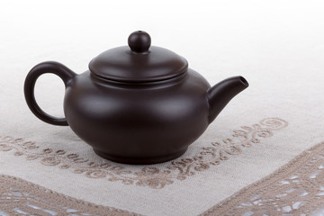 Traditional asian clay teapot with lace doily.