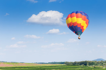 Hot air balloon over green fields