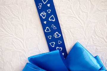 blue ribbon with hearts on a light background