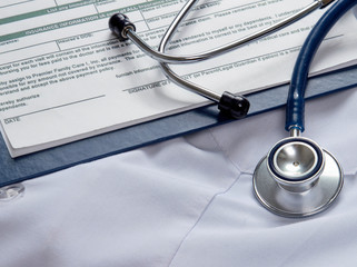 A stethoscope and RX prescription are lying on a medical uniform