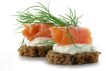 two  salmon canapes with fresh dill garnish, isolated on white b