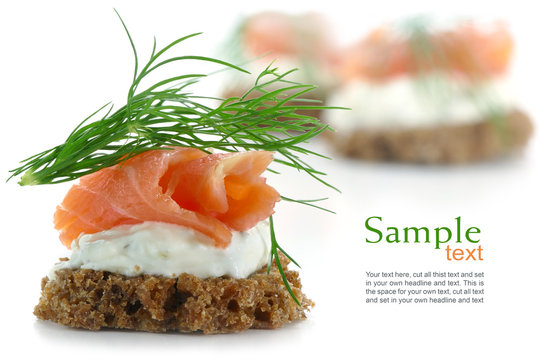 canapes with salmon on cream and dill garnish, isolated on whit