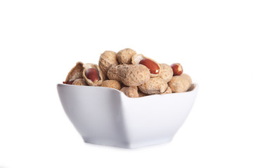 peanuts in shell in white dish