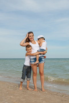 Mother and her two sons having fun on the beach