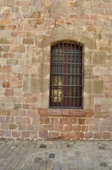 Fototapeta na wymiar Rusty window, Montjuïc castle, Barcelona, Spain; military prison