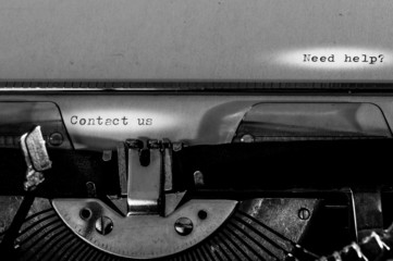 Typewriter; Contact us and Need help? text typed on a paper