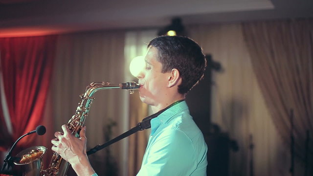 Saxophone player performs on stage with professional light