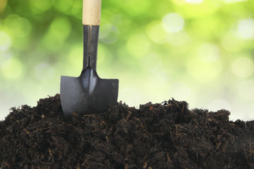 Soil with shovel and green bokeh