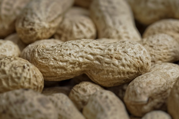 Peeled peanuts on well peanuts in background. Macro image