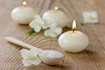 Fototapeta na wymiar Spa composition with sea salt bath, jasmine flowers and candles