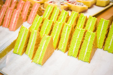 Rows of green cake pieces on shelf in supermarket